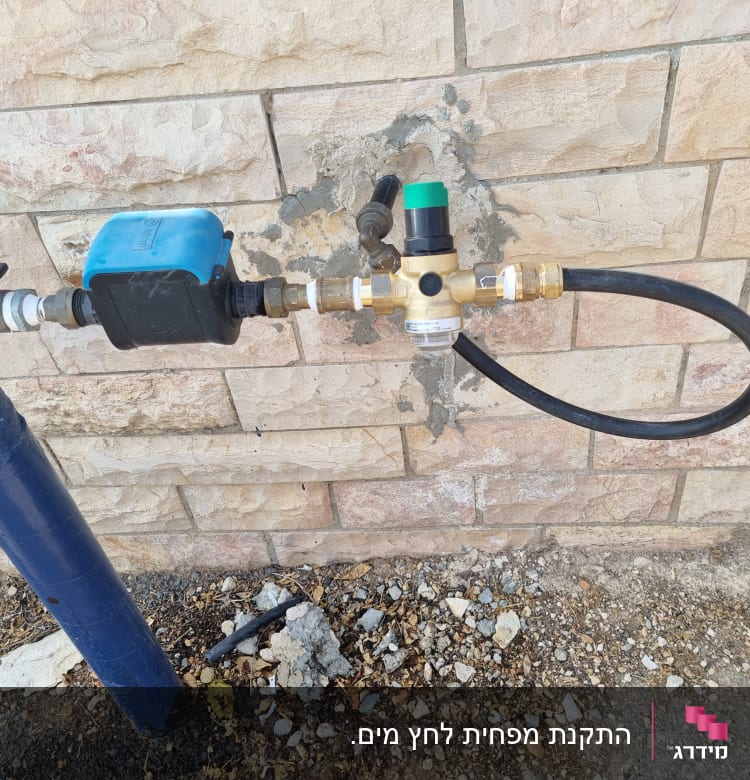 צינור מים עם שסתום וברז על קיר לבנים